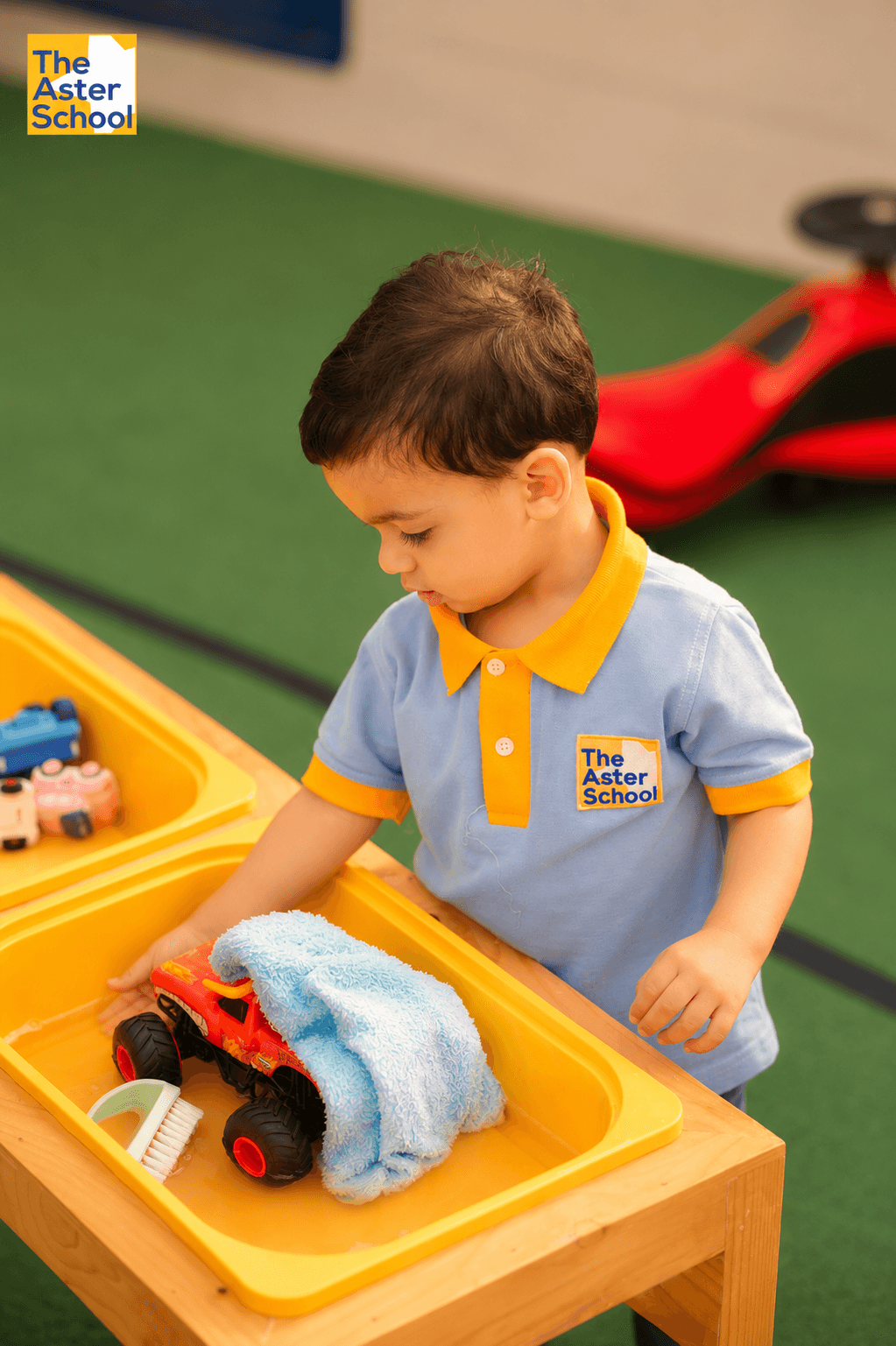 A toddler exploring at a water play table at Aster