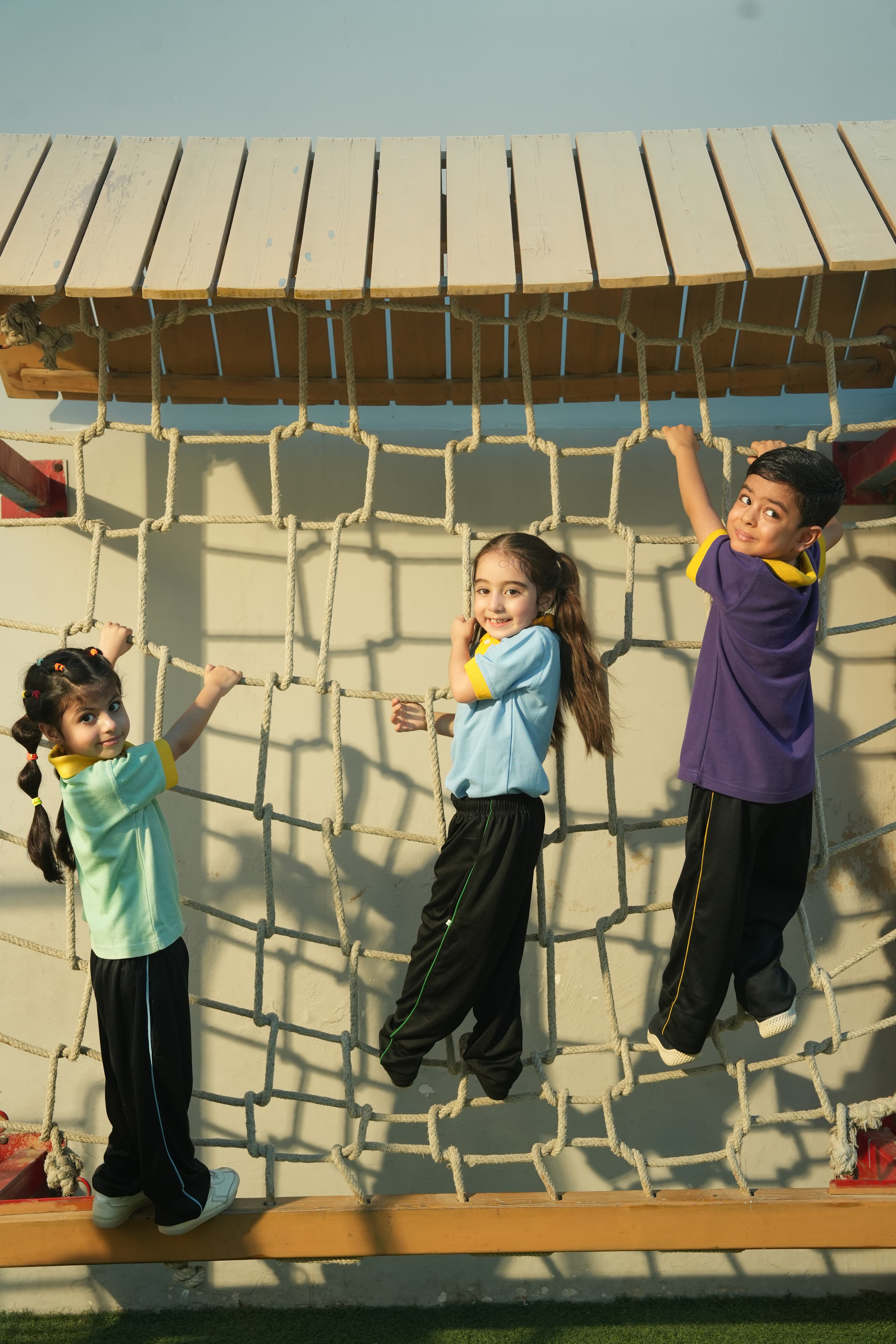 Aster students taking on the climbing net on Sports Day