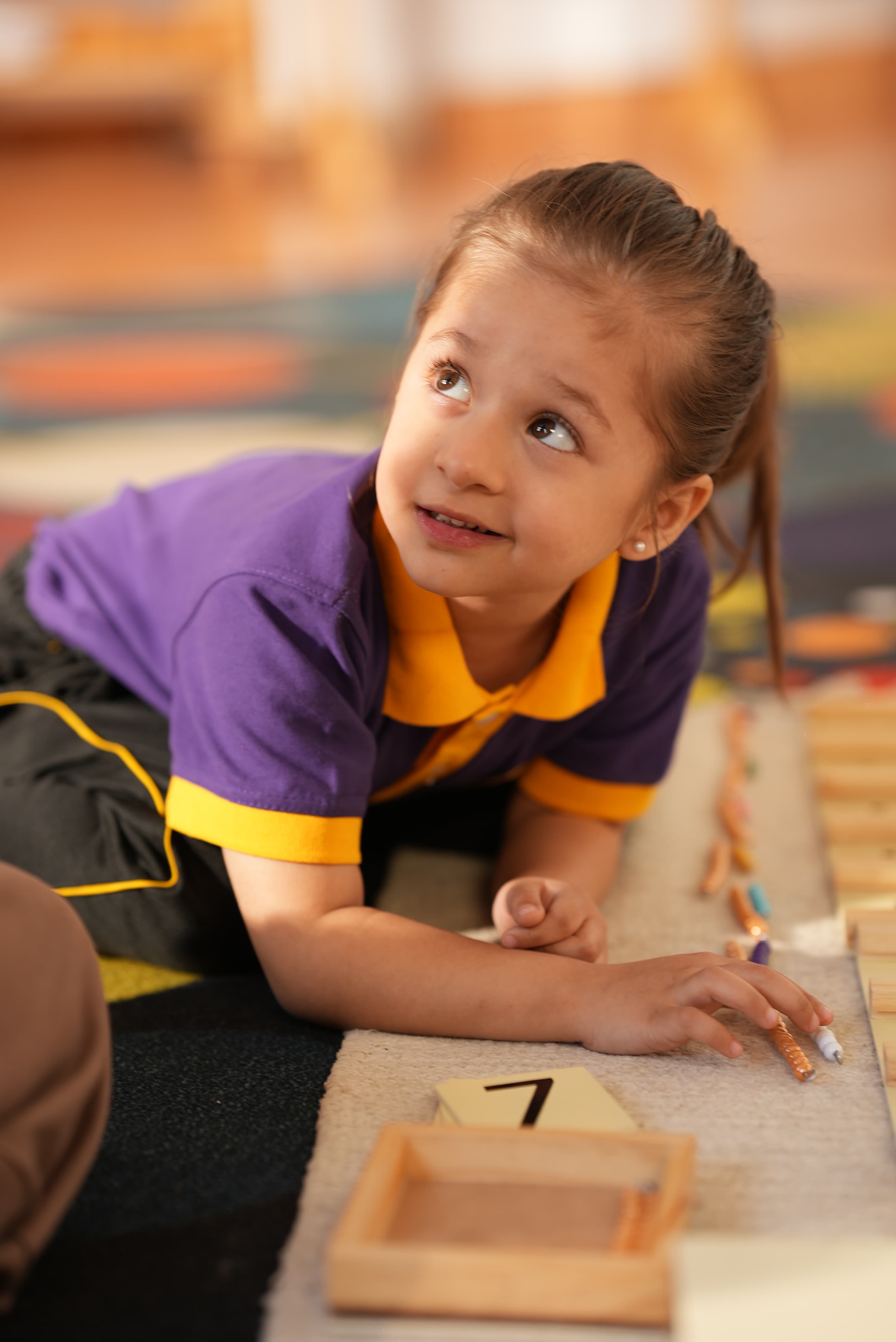 A young learner exploring number rods on the classroom floor